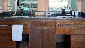 Un baño moderno con un amplio tocador, lavamanos dobles y un espejo grande.