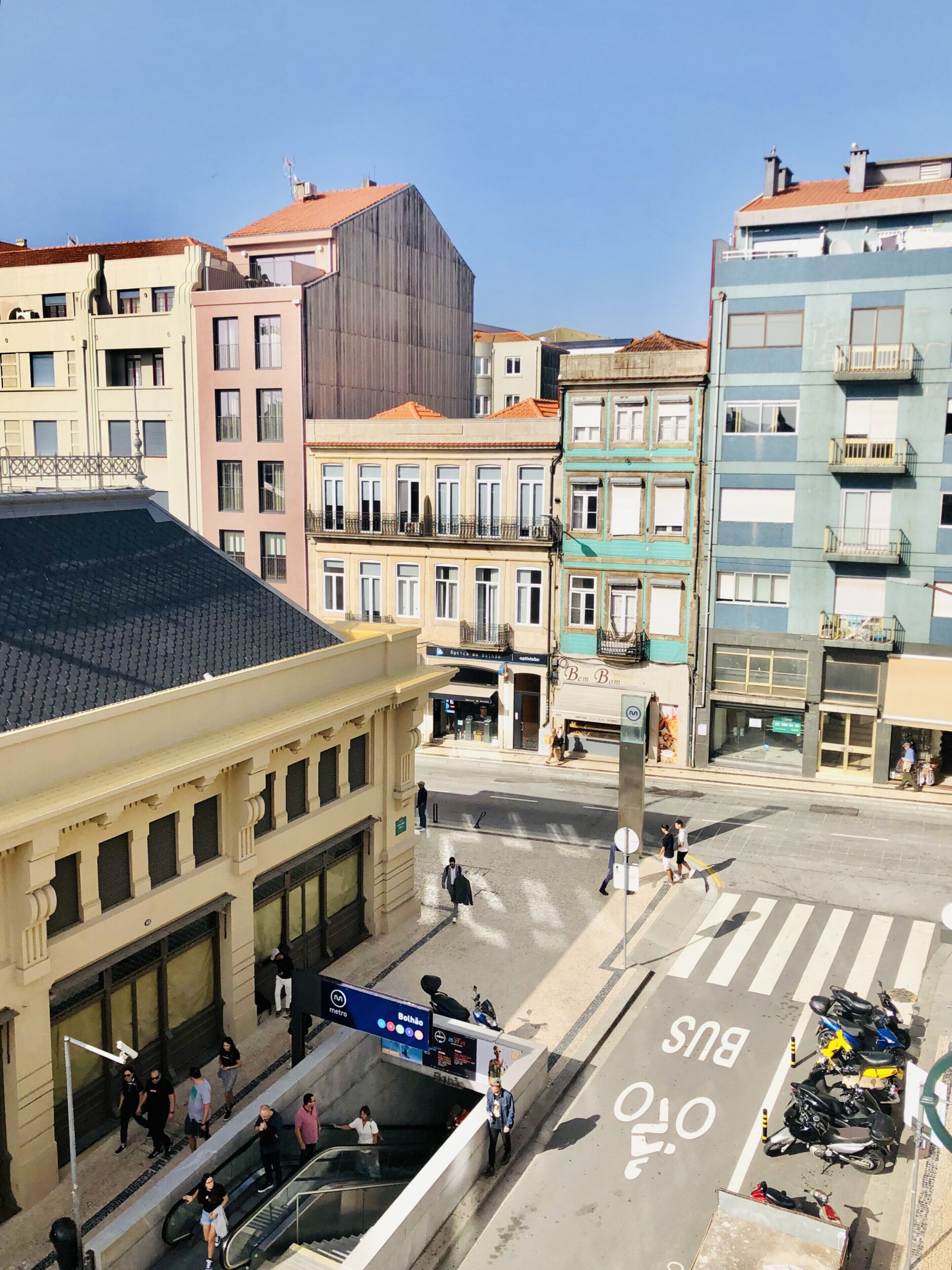 Une rue de la ville avec des immeubles, un panneau indiquant l’emplacement d’une station de métro et un arrêt de bus.