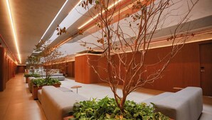 A modern hotel lobby with a long reception desk, seating areas, and potted plants. - Setai Yacht Comfort - By Almare Flats (Joao Pessoa)