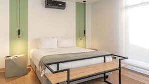 A modern bedroom with a bed, bedside table, and a bench. - NOK Bright 3BR with terrace in Laureles Medellin (Medellín)
