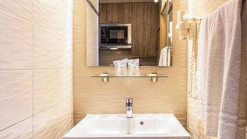Un baño moderno con un espejo grande, un lavabo y un mueble.