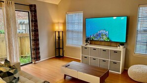 Un salon comprenant un canapé, une table basse, un téléviseur et un meuble de rangement.