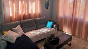 Una sala de estar con un sofá, una mesa de centro y un altavoz de pared.