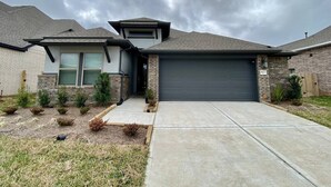 A two-story house with a garage, a front yard with shrubs, and a cloudy sky. - 4-BR Getaway Ideal for Families (Richmond)