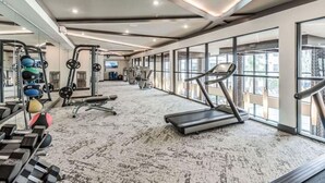 A spacious gym with treadmills, weight machines, and a variety of free weights.