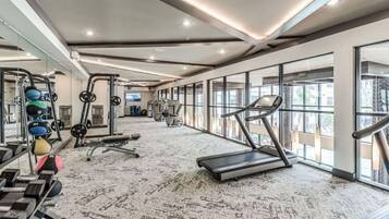 A spacious gym with treadmills, weight machines, and a variety of free weights.
