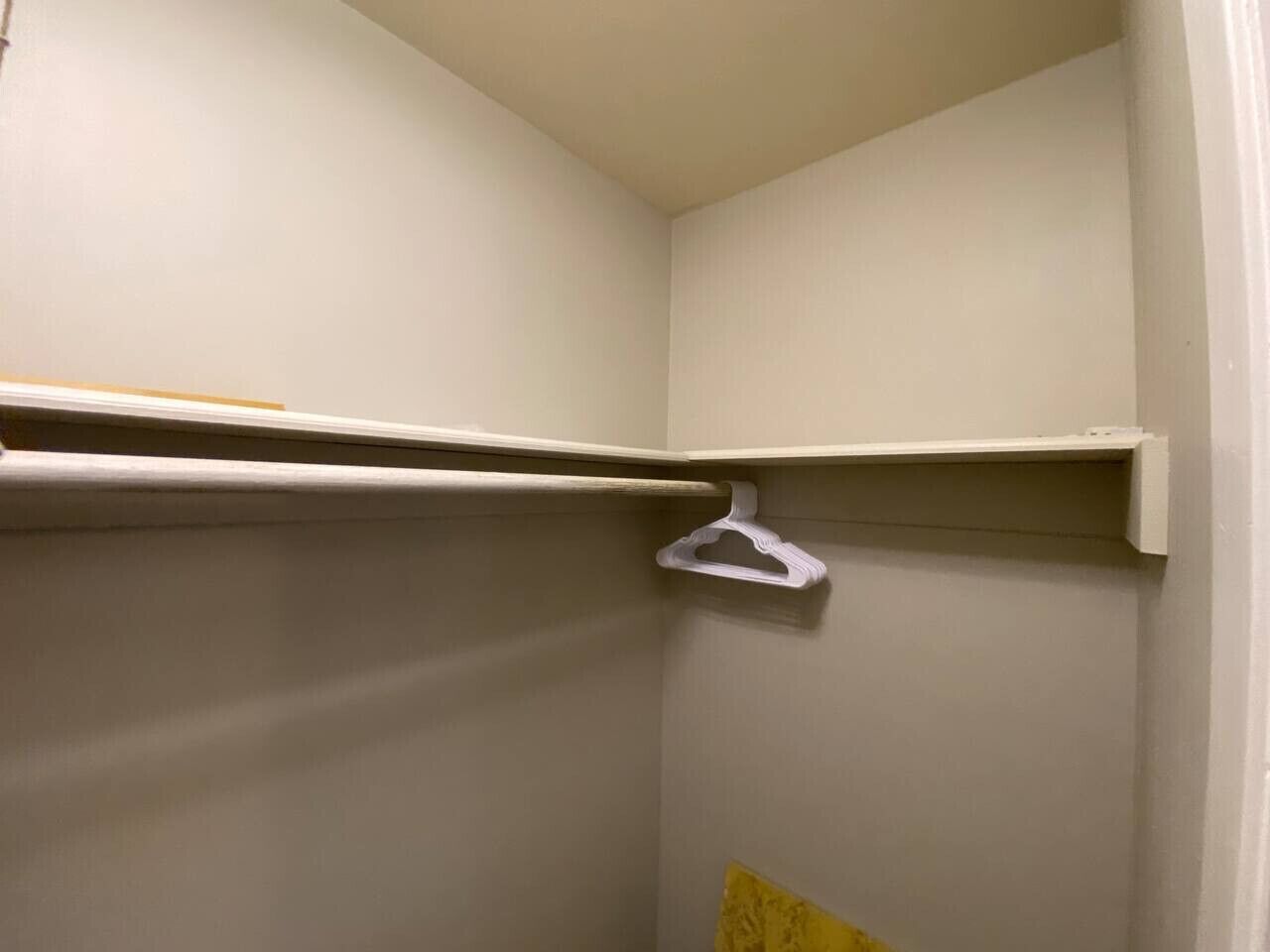 Ein Raumeck mit weißer Wand, weißem Türrahmen und weißem Regal.