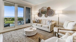 A living room with a sofa, armchair, coffee table, and decorative wall art.