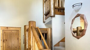 Een houten trap met een leuning, beklede treden en een houten deur.