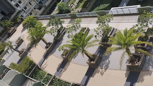 Un edificio de gran altura con múltiples balcones y un patio central con palmeras.