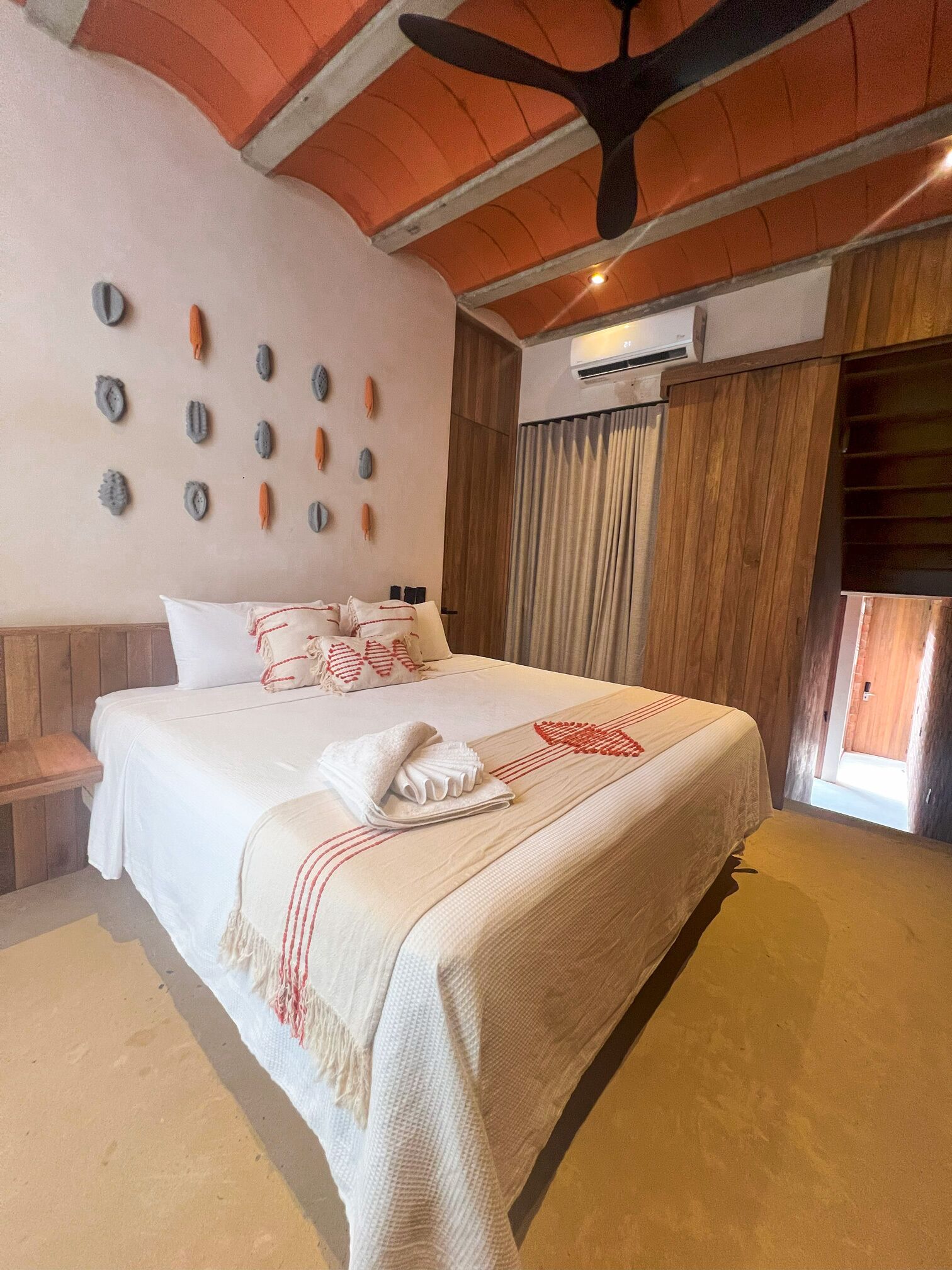 A spacious bedroom with a large bed, wooden headboard, and a ceiling fan.