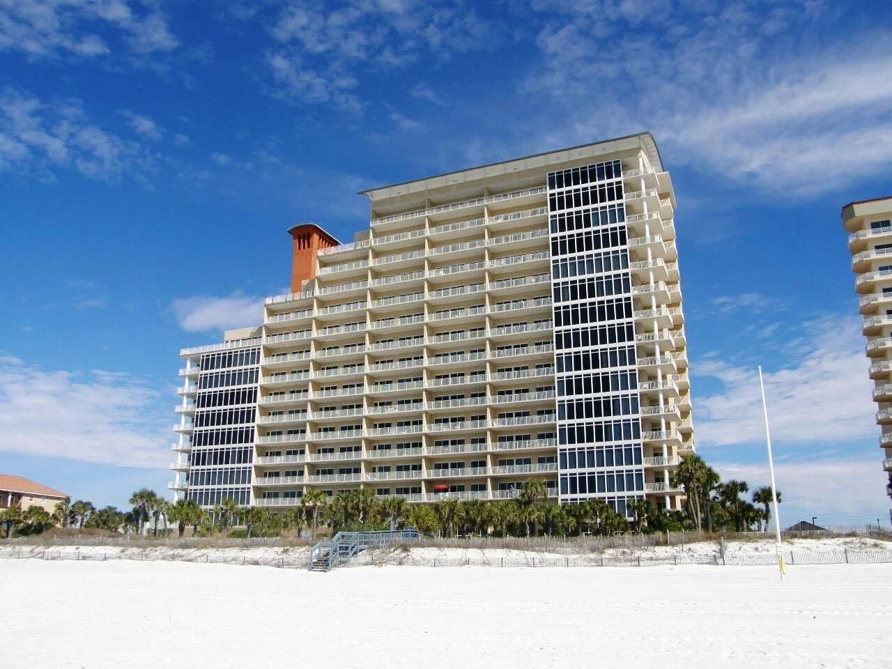 Un hotel a più piani con facciata uniforme, situato vicino a una spiaggia.