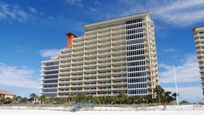 Ein mehrstöckiges Hotel mit einheitlichem Aussehen in Strandnähe.