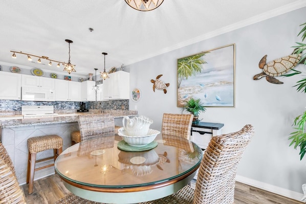 A modern kitchen with white cabinets, a granite countertop, and a hanging light fixture. - Gulf Place Caribbean 313- Sunsets on 30A (Santa Rosa Beach)