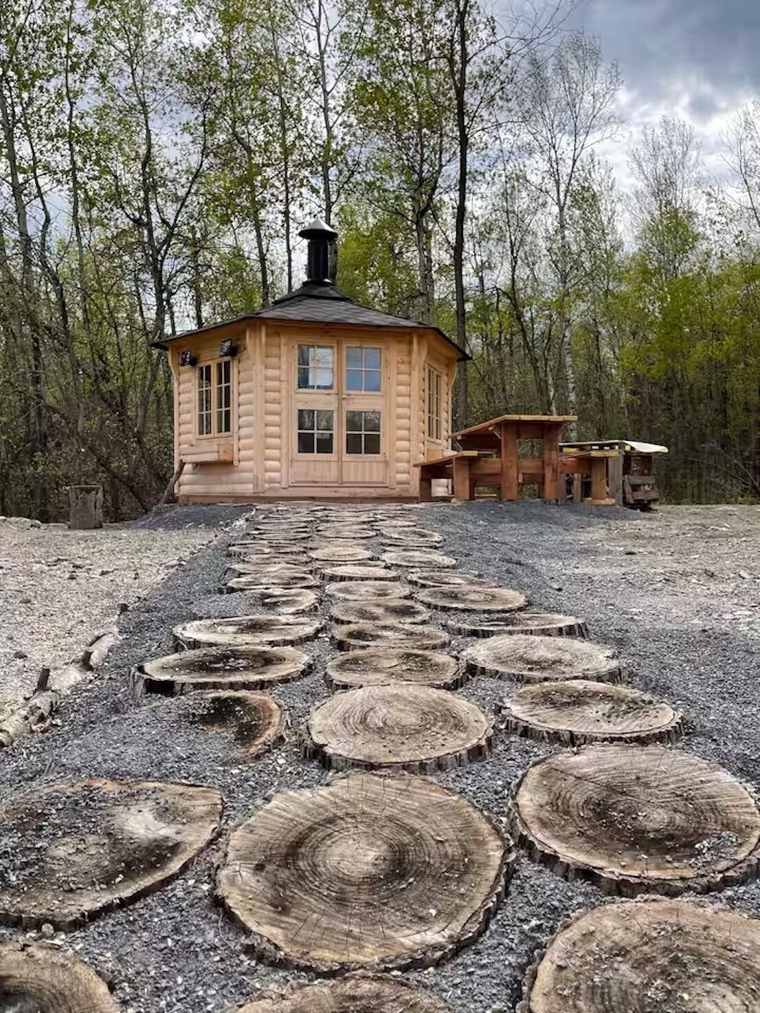 A log cabin with a chimney, a porch, and a deck.