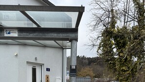 Un edificio con un ingresso coperto, un segnale di parcheggio e un'auto parcheggiata davanti.