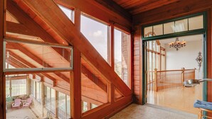 A spacious room with large windows, a wooden ceiling, and a view of a balcony with a railing. - 366 Shared Acres, Lake Access: Ozark Getaway! (Shirley)