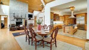 A spacious living room with a fireplace, wooden ceiling, and a dining area with a large table and chairs. - 366 Shared Acres, Lake Access: Ozark Getaway! (Shirley)