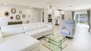 A modern living room with a white sofa, a glass coffee table, and a white armchair. - 3 Mi to Beach: Pet-Friendly Home in Port Charlotte (Port Charlotte)