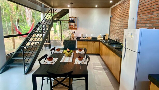 Une cuisine moderne avec un coin repas, dotée d’un escalier menant à un espace extérieur.