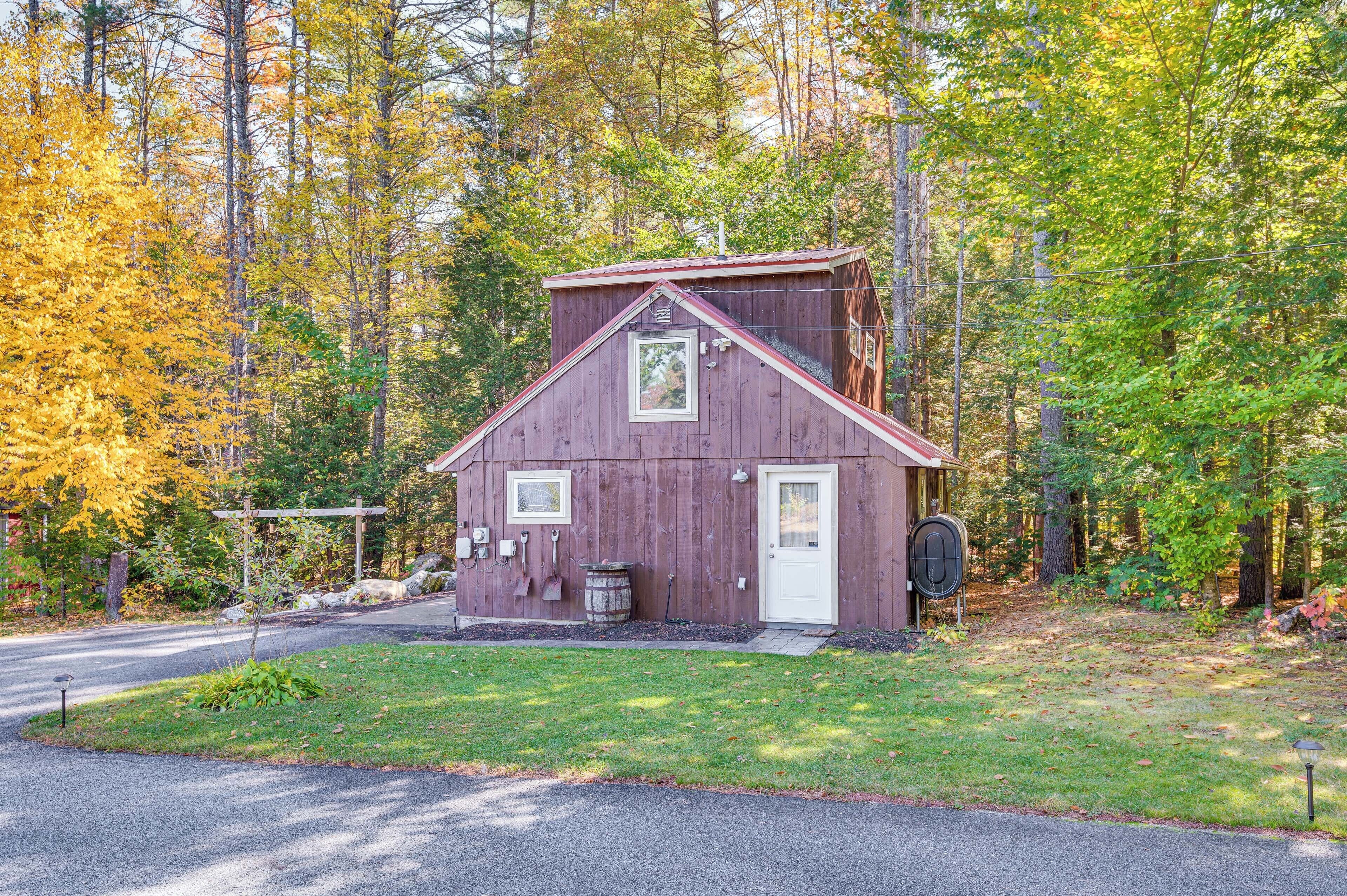 Une cabane en bois rustique, dotée d’un toit à deux versants, d’une porte d’entrée et d’un petit porche.