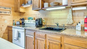 Una cucina in legno con un fornello, un lavello e diversi elettrodomestici.