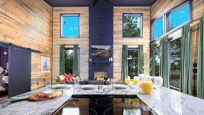 A modern kitchen with a central island, a built-in stove, and a fireplace. - Couples Retreat: Sauna, Massage Chairs, Hot Tub (Broken Bow)