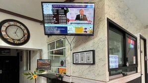 A hotel reception area with a digital display, a clock, and a plant. - Hotel Galería & Boutique (Mexico City)