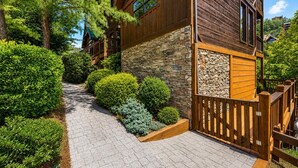 A wooden building with stone walls, a stone staircase, and a wooden fence.