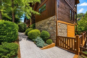 Un bâtiment en bois avec des murs en pierre, un escalier en pierre et une clôture en bois.