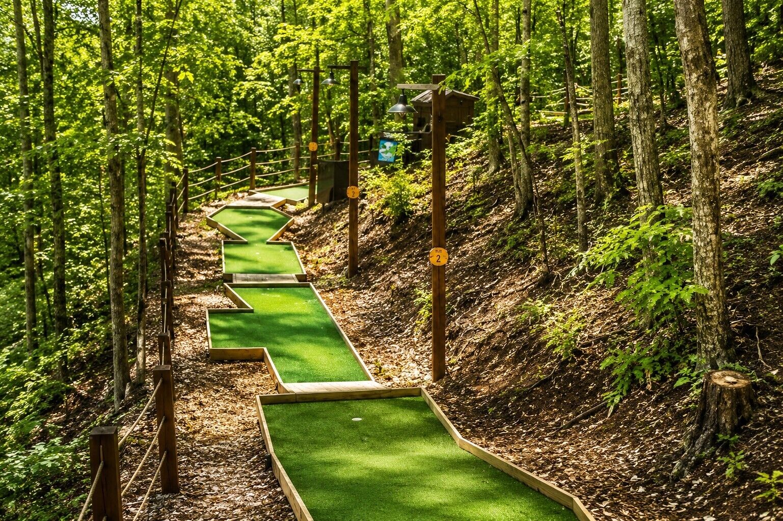 Un parcours de mini-golf avec un chemin en gazon synthétique vert, des bordures en bois et une structure en bois portant une enseigne.