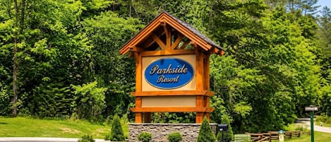 Skiltning for Parkside Resort med en trækonstruktion, omgivet af grønt.