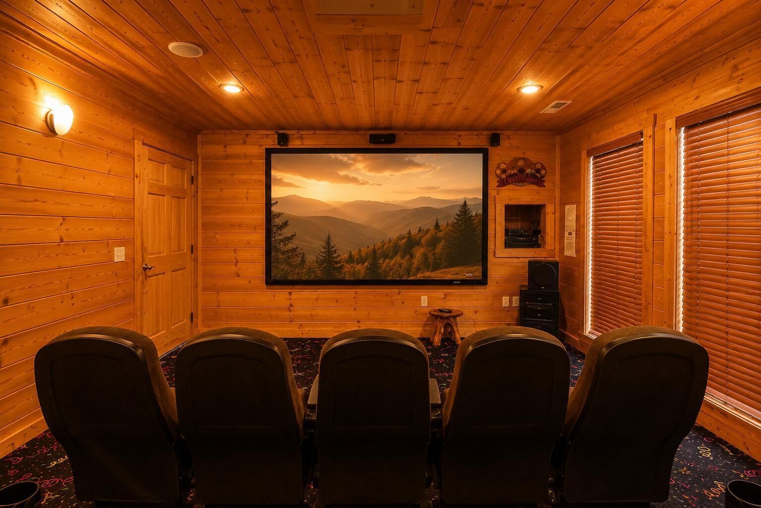 A wooden interior with a large TV screen displaying a mountain landscape, four chairs, and a small table.