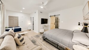 A modern bedroom with a bed, a sofa, a TV, and a desk. - Orchid: Studio Apt, 4 Minute Walk to A&M (College Station)
