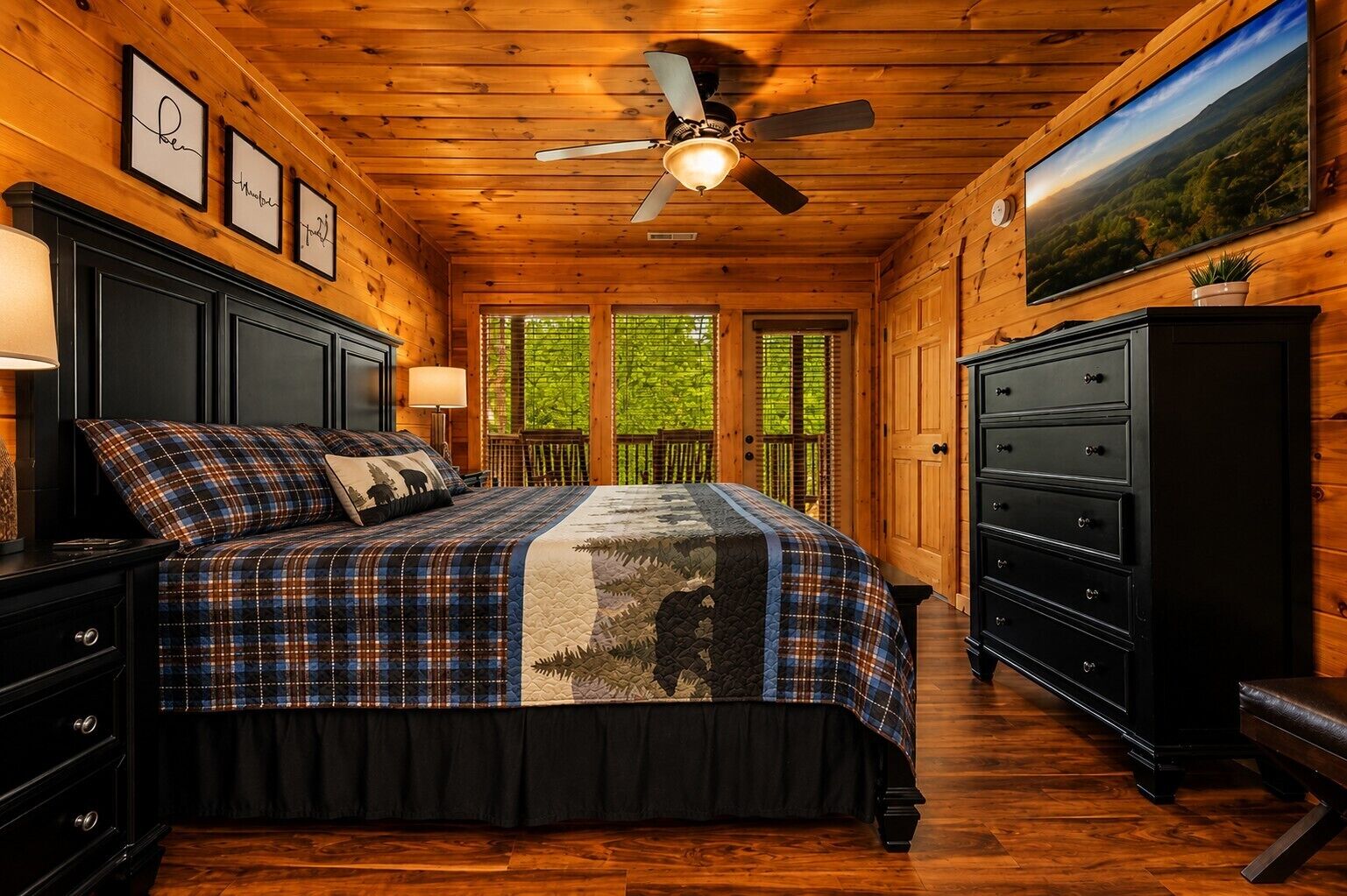 A bedroom with a bed, dresser, nightstand, and a ceiling fan.