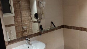 A bathroom with a white sink, a mirror, a handheld showerhead, and a soap dispenser. - Arjan Almutamyezah serviced apartments (Jeddah)