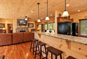 A wooden interior with a kitchen, bar area, and seating.
