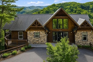 A lodge with a stone facade, wooden beams, and a metal roof.