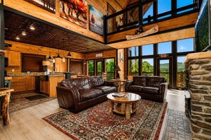 A spacious living area with leather sofas, a coffee table, and a large rug. - Near Dollywood + Resort Amenities Included (Pigeon Forge)