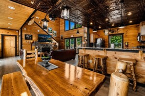 A rustic interior with a wooden bar, seating area, and a kitchen. - Near Dollywood + Resort Amenities Included (Pigeon Forge)