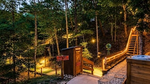 A wooden deck with a hot tub, a sign indicating 'PUTT-PUTT HIGH POINTS,' and a wooden structure with a ladder.