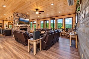 A spacious living area with a stone fireplace, leather sofas, and a television. - Near Dollywood + Resort Amenities Included (Sevierville)