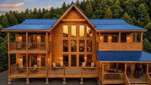 A two-story log cabin with a balcony and a covered porch.