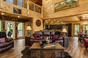 A spacious living room with a leather sofa, a wooden coffee table, and a dining area with a wooden table and chairs. - Near Dollywood + Resort Amenities Included (Sevierville)