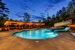 A swimming pool with a slide, lounge chairs, and a covered seating area with string lights. - Near Dollywood + Resort Amenities Included (Sevierville)