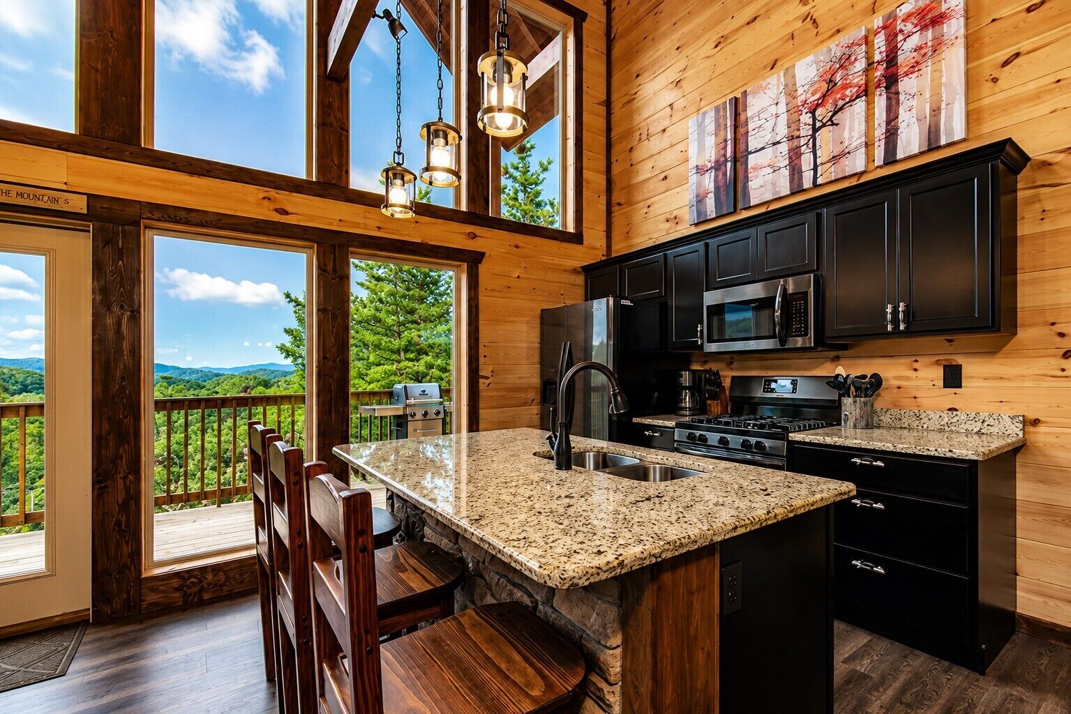 A modern kitchen with granite countertops, black cabinetry, and a large island.