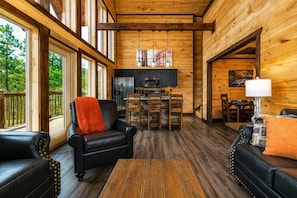 A cozy cabin interior with a dining area, kitchen, and seating space.