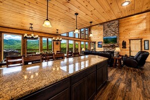 A spacious kitchen with a granite countertop, wooden cabinets, and a stone backsplash.
