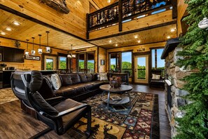A spacious living room with a leather sofa, a coffee table, and a view of the outdoors.