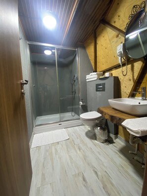 A bathroom with a glass-enclosed shower, a toilet, and two sinks. - Lepista Garden (Mengen)